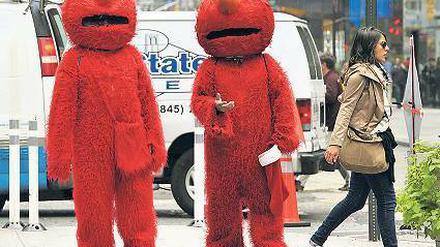 Leute haben sich als Elmo verkleidet und laufen durch die Straßen von New York.