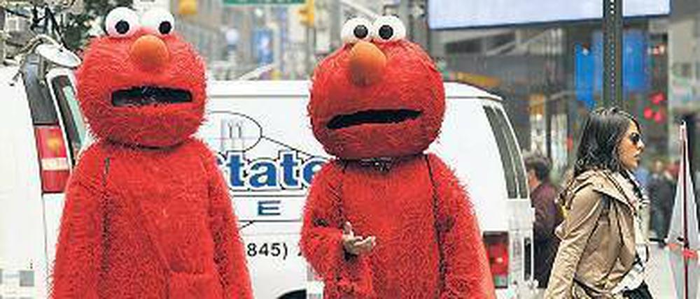 Leute haben sich als Elmo verkleidet und laufen durch die Straßen von New York.