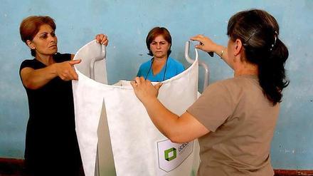 Urnengang in Georgien: Wahlhelferinnen bereiten eine Abstimmungskabine vor.