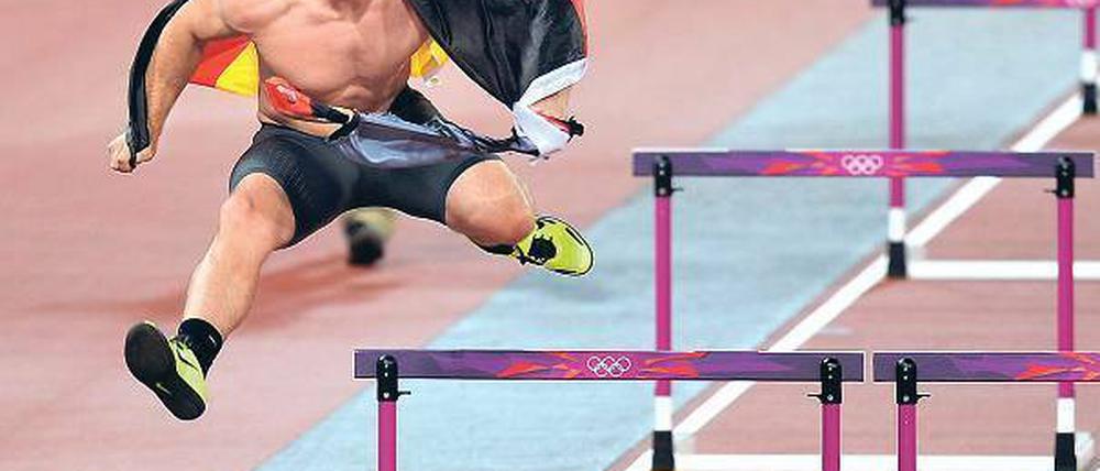Die Hürde genommen. Robert Harting übte sich auf seiner Ehrenrunde unter dem Jubel der Stadionbesucher noch in einer anderen Disziplin. Foto: dapd