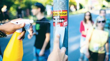 Putzaktion. Dutzende Menschen entfernten am Mittwochabend bei einem Kiezspaziergang in Johannisthal Aufkleber, Plakate und Schmierereien von Neonazis. Das Projekt „Uffmucken“ hatte zu der Aktion aufgerufen. Foto: dpa/Jörg Carstensen