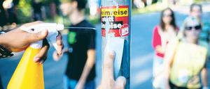 Putzaktion. Dutzende Menschen entfernten am Mittwochabend bei einem Kiezspaziergang in Johannisthal Aufkleber, Plakate und Schmierereien von Neonazis. Das Projekt „Uffmucken“ hatte zu der Aktion aufgerufen. Foto: dpa/Jörg Carstensen