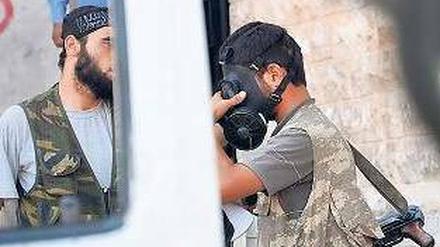 Auf alles vorbereitet. Ein Rebell probiert eine Gasmaske an.