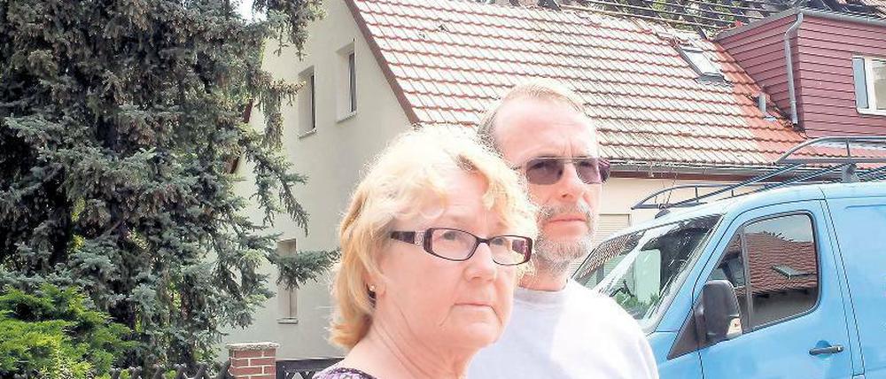 Vor ihrem stark beschädigten Haus: Das Ehepaar Dörger.