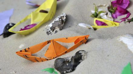 Der Unglücksort nach dem tragischen Unfall: Kinder haben Papierschiffchen und Blumen im Sand abgelegt.