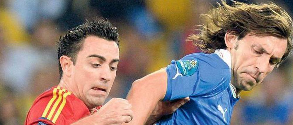 Kampfkunst. Statt wie bisher offensiv zu zaubern, hat Andrea Pirlo (r.) defensiv alle Hände voll zu tun mit Xavi.