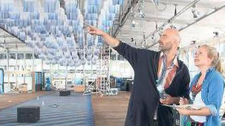 So wird’s gemacht. Kreativberater Arne Koefoed und eine Mitarbeiterin beim Messeaufbau. An der Decke hängen 1000 in Tauchbädern weißblau gefärbte Shirts.