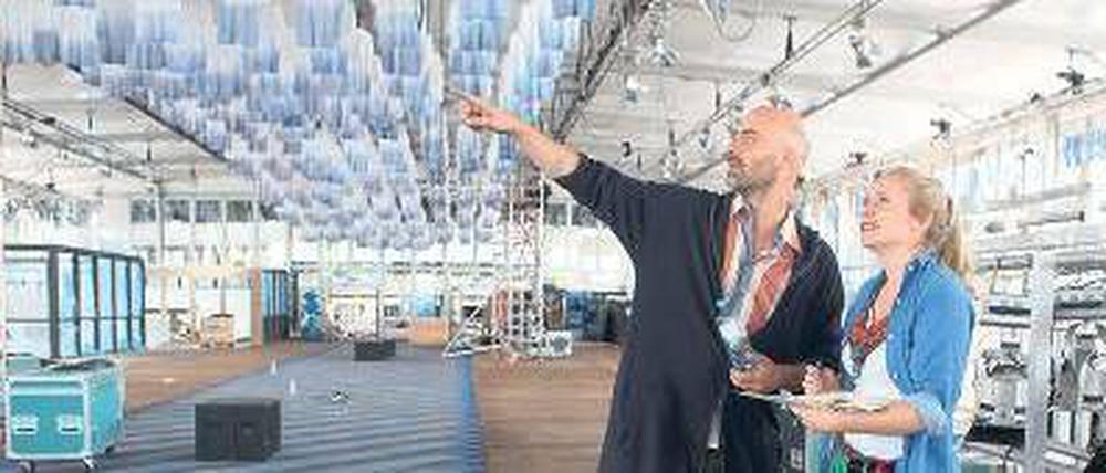 So wird’s gemacht. Kreativberater Arne Koefoed und eine Mitarbeiterin beim Messeaufbau. An der Decke hängen 1000 in Tauchbädern weißblau gefärbte Shirts.