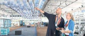 So wird’s gemacht. Kreativberater Arne Koefoed und eine Mitarbeiterin beim Messeaufbau. An der Decke hängen 1000 in Tauchbädern weißblau gefärbte Shirts.