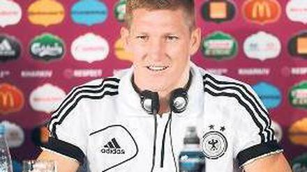 Musik ist, wenn man’s trotzdem hört: Bastian Schweinsteiger lauscht auf einer Pressekonferenz den Beats. Foto: dpa