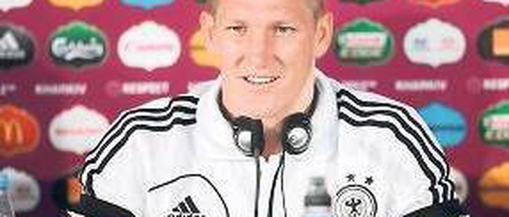 Musik ist, wenn man’s trotzdem hört: Bastian Schweinsteiger lauscht auf einer Pressekonferenz den Beats. Foto: dpa