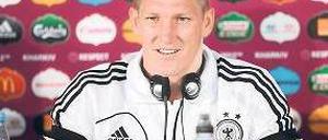 Musik ist, wenn man’s trotzdem hört: Bastian Schweinsteiger lauscht auf einer Pressekonferenz den Beats. Foto: dpa