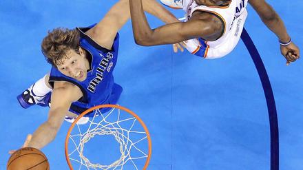 Superstars im direkten Duell. Dirk Nowitzki legt den Basketball an Kevin Durant vorbei in den Korb.