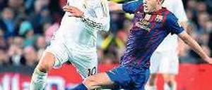 Klassisch gut. Reals Mesut Özil (vorn) läuft Andres Iniesta davon. Foto: dapd