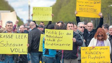 Fahrer aller Berliner Taxiverbände protestierten am Montag gegen die Gebühren am BER. Tausende blockierten die Straße des 17. Juni.Fotos: Ch. Mang/dpa, Schuh