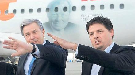 Die Hände zum Himmel. Berlins Regierender Klaus Wowereit (SPD) und Easyjet-Deutschland-Chef Thomas Haagensen vor einem Airbus des Billigfliegers, der mit Willy-Brandt-Konterfei am Rumpf europaweit für Berlins neuen Flughafen BER werben soll.