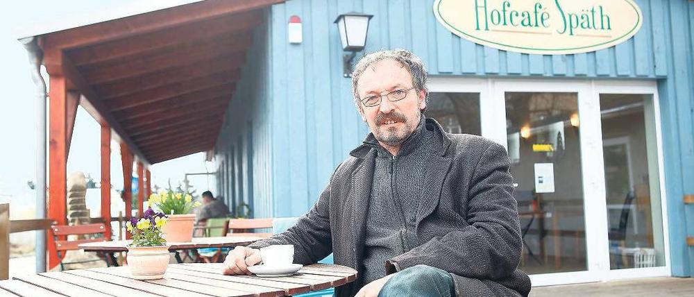 Haus gegen Pflanzen. Holger Zahn hat es sich auf der Terrasse seines Cafés bequem gemacht. Für den Bau hat er nicht einen Cent bezahlt. 