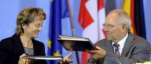 Bundesfinanzminister Wolfgang Schäuble (CDU) und die Schweizer Bundesrätin Eveline Widmer-Schlumpf tauschen im Finanzministerium in Berlin nach der Unterzeichnung eines Steuerabkommens die Mappen aus.