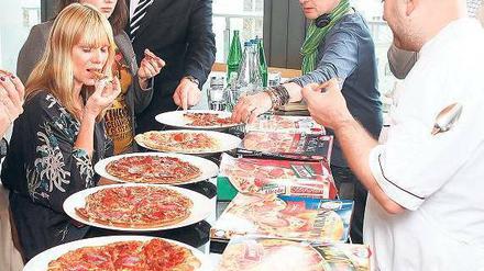 Biss in die Schmelzmasse. Die Runde der Pizza-Tester. Foto: Georg Moritz