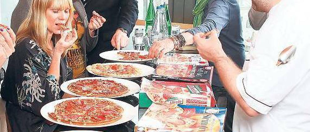 Biss in die Schmelzmasse. Die Runde der Pizza-Tester. Foto: Georg Moritz
