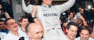 Pose mit Pott. Für seinen ersten Sieg wird Nico Rosberg auf Händen getragen. Foto: dapd