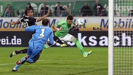 Wolfsburgs Mario Mandzukic (r.) schießt das 1:0. Davon können auch Hamburgs Torwart Jaroslav Drobny und Michael Mancienne ihn nicht abhalten.