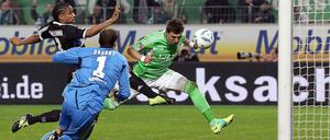 Wolfsburgs Mario Mandzukic (r.) schießt das 1:0. Davon können auch Hamburgs Torwart Jaroslav Drobny und Michael Mancienne ihn nicht abhalten.