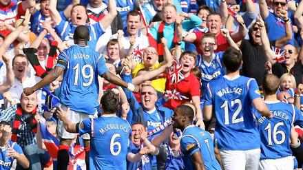 Sone Aluko (l.) bejubelt vor den Rangers-Anhängern seinen Treffer zur 1:0-Führung.
