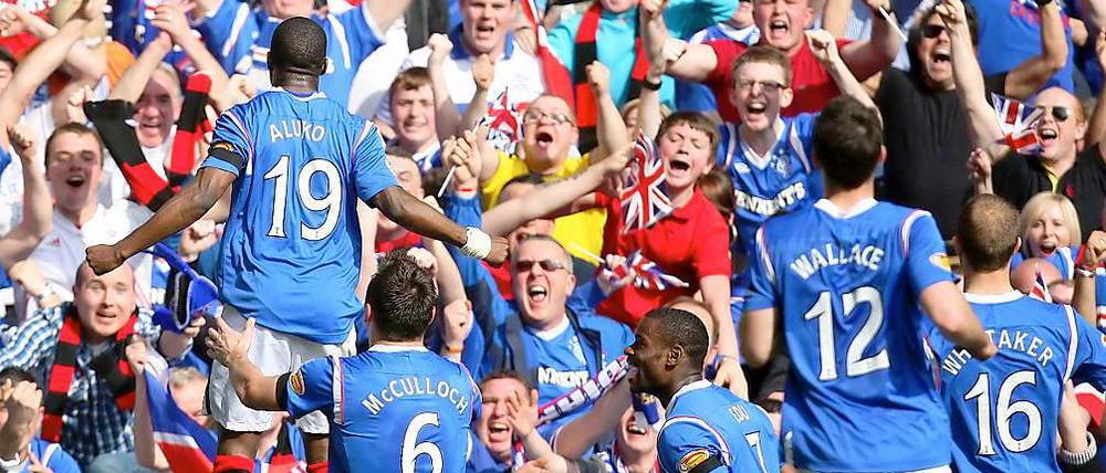 Sone Aluko (l.) bejubelt vor den Rangers-Anhängern seinen Treffer zur 1:0-Führung.