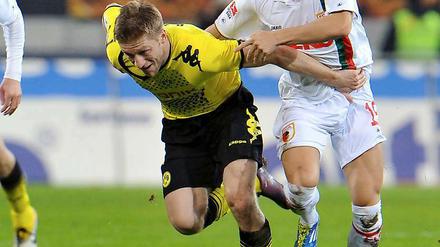 Der Dortmunder Jakub Blaszczykowski (l.) im Laufduell mit dem Augsburger Matthias Ostrzolek (r.).
