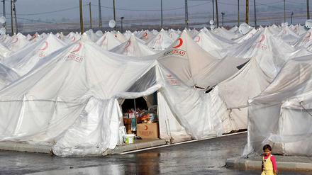 Ein syrisches Flüchtlingsmädchen steht vor Zelten des Roten Halbmondes in der türkischen Provinz Hatay.