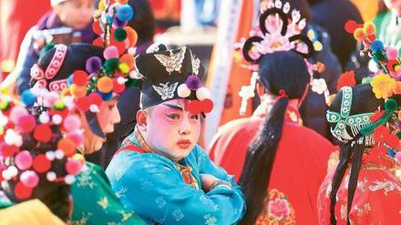 Vor dem großen Auftritt. Ein Schauspieler in traditionellem Kostüm wartet beim Neujahrsfest auf seinen Einsatz vor dem Dongyue-Tempel in Peking, der vor 700 Jahren gegründet wurde.
