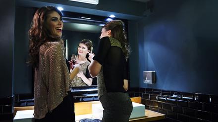 Mädels beim Geheimnistausch auf der Toilette. Aber es reicht, vor dem Spiegel zu plaudern.