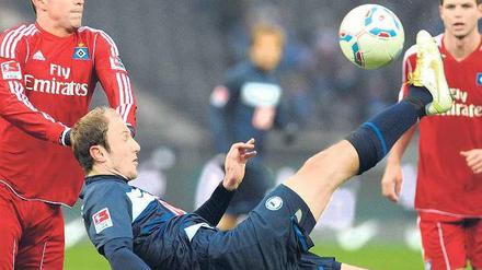 Im freien Fall, den Fuß am Ball. Roman Hubnik (Mitte, im Zweikampf gegen Hamburgs Tomas Rincon) nützte am Sonnabend auch eine gute Technik nichts. Die Berliner müssen sich nun mit dem Abstiegskampf auseinandersetzen. Foto: dpa
