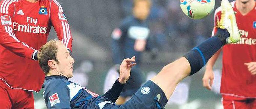 Im freien Fall, den Fuß am Ball. Roman Hubnik (Mitte, im Zweikampf gegen Hamburgs Tomas Rincon) nützte am Sonnabend auch eine gute Technik nichts. Die Berliner müssen sich nun mit dem Abstiegskampf auseinandersetzen. Foto: dpa