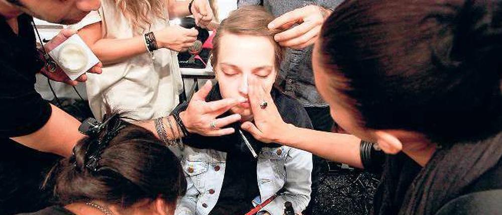 Wischen, leiden, legen. Hinter den Kulissen der Modewoche geht es hektisch zu. Wer hier beruflich Fuß fassen will, sollte cool bleiben können. Foto: Reuters/Gestaltung: Anikka Bauer