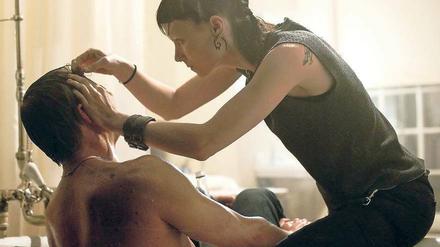Lisbeth Salander (Rooney Mara) verarztet den Reporter Mikael Blomkvist (Daniel Craig). Kinostart ist am Donnerstag.. 