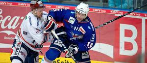 Der Mannheimer Ken Magowan (r) schirmt gegen den Berliner Jimmy Sharrow den Puck ab.