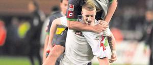 Oben bleiben. Marco Reus hat noch Kraft, Torschütze Mike Hanke zu tragen. Foto: AFP