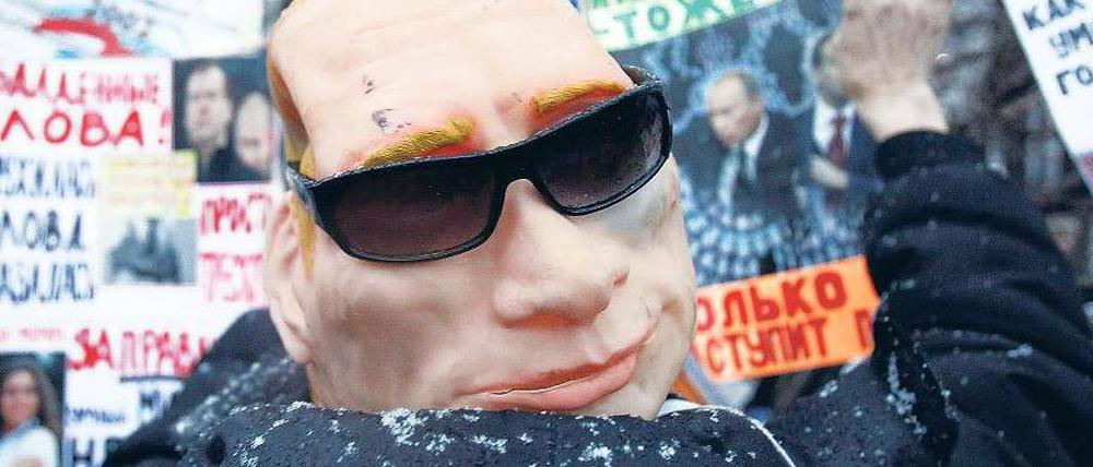 Allgegenwärtig. Bei der Großkundgebung in Moskau am Samstag trug ein Demonstrant eine Putin-Maske. Der russische Premier lässt Kritik am Ablauf der Duma-Wahl zurückweisen. Foto: Reuters
