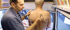 Der Mainzer Obdachlosenarzt Gerhard Trabert untersucht in seinem Arztmobil einen Mann.