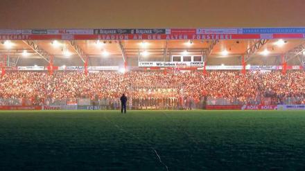 Dann singt mal schön. Die Fußballer vom Zweitligisten 1. FC Union sind schon aus dem DFB-Pokal ausgeschieden, die Fans strömen trotzdem ins Stadion. Mit Kerze und Gesangsbuch. Foto: dpa