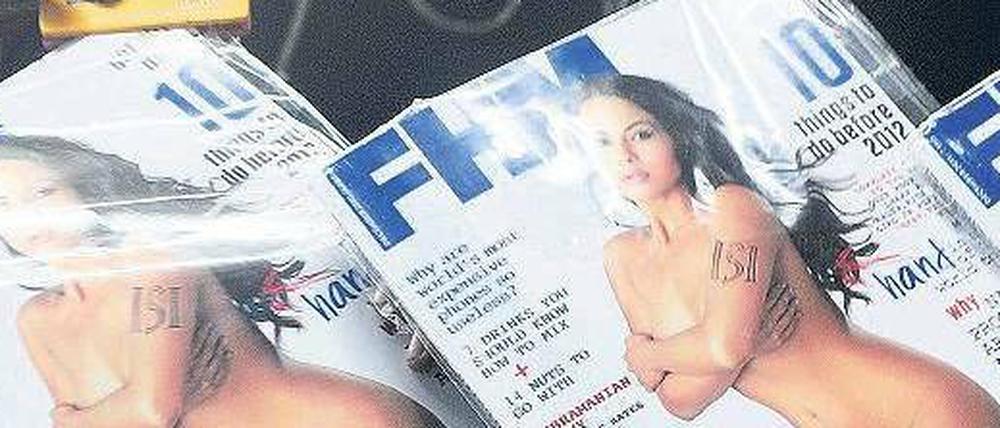 Der schöne Arm des Geheimdiensts. Ein Verkäufer hängt das Magazin auf.