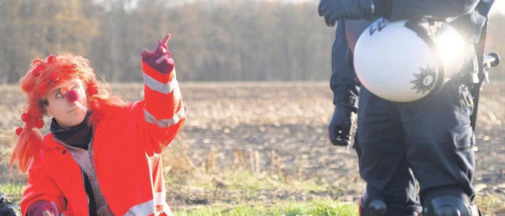 Kultur im Kampf. Ein als Clown verkleideter Castor-Gegner spricht am Montag in Laase an einem Camp namens „Musen-Palast“ mit einem Polizisten. Foto: Axel Heimken/dapd