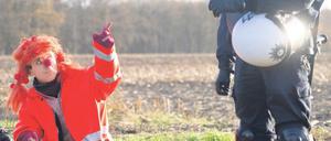 Kultur im Kampf. Ein als Clown verkleideter Castor-Gegner spricht am Montag in Laase an einem Camp namens „Musen-Palast“ mit einem Polizisten. Foto: Axel Heimken/dapd