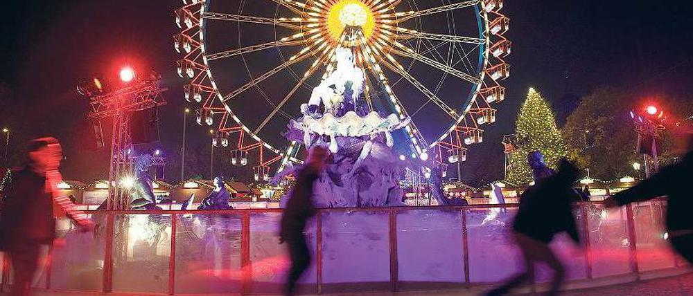 Kalt und heiß. Am Neptunbrunnen vor dem Roten Rathaus können Schlittschuhläufer vor der Kulisse des Weihnachtsmarktes ihre Runden ziehen und sich danach am Glühweinstand aufwärmen. Foto: dapd/Steffi Loos