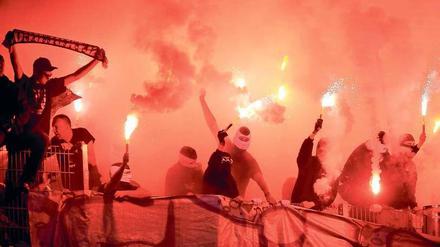 Zeichen mit Rauch. Feuerwerk im Stadion ist und bleibt strafbar. Auch deswegen vermummen sich viele Fans beim Abbrennen von Bengalos, wie hier Anhänger des Hamburger SV im Bundesligaspiel gegen Werder Bremen.