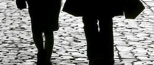 Eine Mutter läuft mit ihrer Tochter an der Hand die Straße entlang.