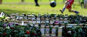 Das Leben muss weitergehen. Kinder spielen auf einer Wiese neben einer Trauerstätte für die 77 Opfer der Anschläge in Norwegen.