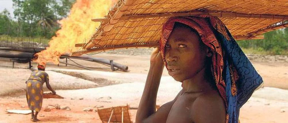 Frauen trocknen Tapiokastärke für die Nahrungsmittelzubereitung an einer Förderstation des Ölkonzerns Shell. Seit Jahrzehnten wird hier mitgefördertes Gas ohne Rücksicht auf die Umwelt abgefackelt. In Zukunft soll nicht nur mit deutscher Hilfe die Gaswirtschaft modernisiert, sondern auch die Solarkraft genutzt werden.